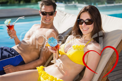 Composite image of smiling couple with drinks sitting by swimmin