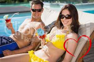 Composite image of smiling couple with drinks sitting by swimmin