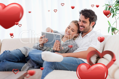 Composite image of in love couple using a tablet computer