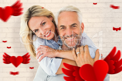 Composite image of happy couple standing and hugging