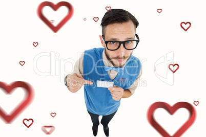 Composite image of geeky hipster looking at camera pointing at c