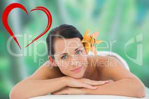 Composite image of beautiful brunette relaxing on massage table