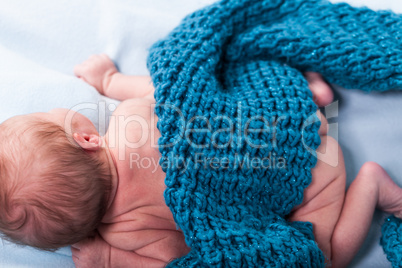 Small infant wrapped in knitted fabric