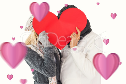 Composite image of couple in winter fashion posing with heart sh