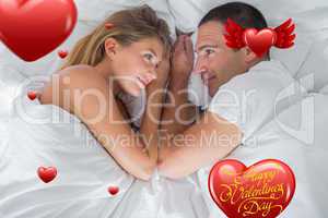Composite image of cute couple lying and looking at each other i