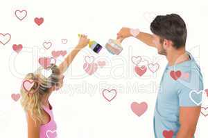 Composite image of young couple painting with brushes