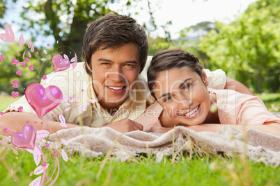 Composite image of two friends lying together on a blanket while