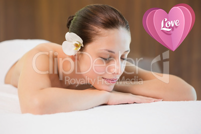 Composite image of beautiful woman lying on massage table at spa