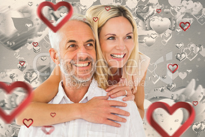 Composite image of happy man giving his partner a piggy back Composite image of happy man giving his partner a piggy back