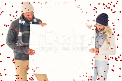 Composite image of attractive couple in winter fashion showing p