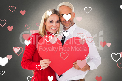 Composite image of handsome man getting a heart card form wife