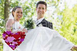 Composite image of groom carrying bride in garden