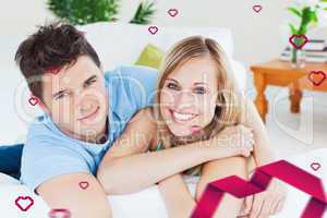Composite image of smiling beatiful couple sitting on a sofa