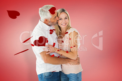 Composite image of affectionate man kissing his wife on the chee