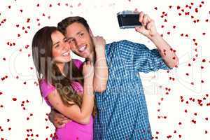 Composite image of couple taking selfie with digital camera