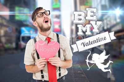 Composite image of geeky hipster crying and holding heart card