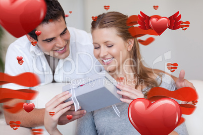 Composite image of woman opening the gift she got from her boyfr