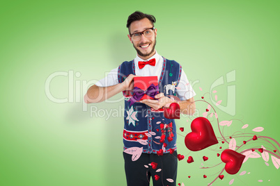 Composite image of geeky hipster offering christmas gift