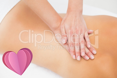 Composite image of woman receiving back massage at spa center