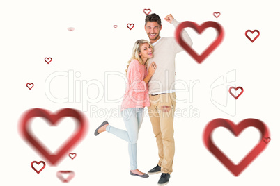 Composite image of attractive couple smiling and cheering