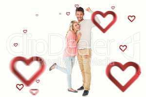 Composite image of attractive couple smiling and cheering