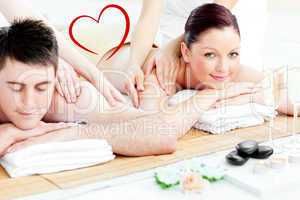 Composite image of attractive young couple enjoying a back massa