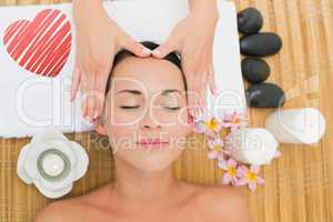 Composite image of smiling brunette enjoying a head massage