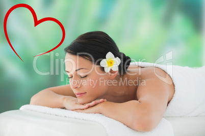 Composite image of beautiful brunette relaxing on massage table