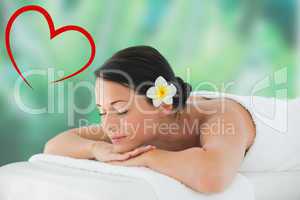 Composite image of beautiful brunette relaxing on massage table