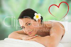 Composite image of beautiful brunette relaxing on massage table