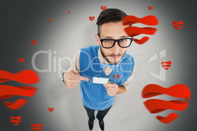 Composite image of geeky hipster looking at camera pointing at c