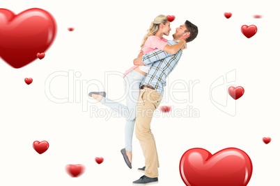 Composite image of handsome man picking up and hugging his girlf