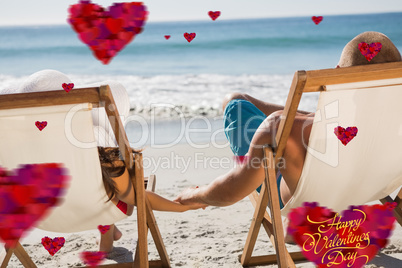 Composite image of cute couple holding hands while lying on thei