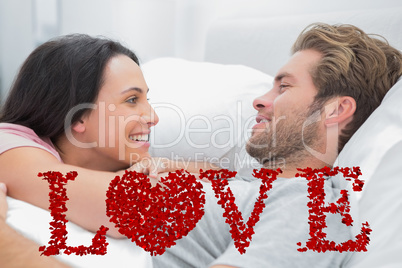 Composite image of cheerful couple awaking and looking at each o