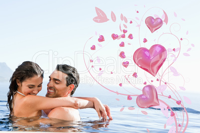 Composite image of couple hugging in the pool