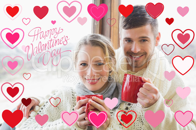 Composite image of loving couple in winter clothing with coffee