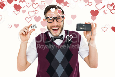 Composite image of geeky hipster holding a retro tape cassette p