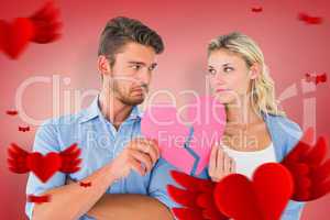 Composite image of couple holding two halves of broken heart