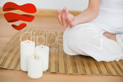 Composite image of woman sitting in lotus pose beside white cand