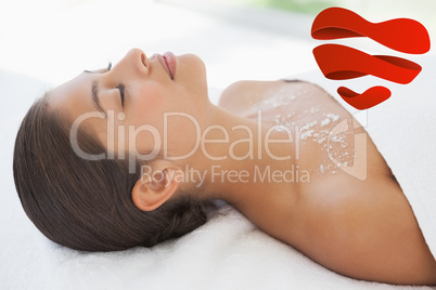 Composite image of beautiful brunette lying on massage table wit