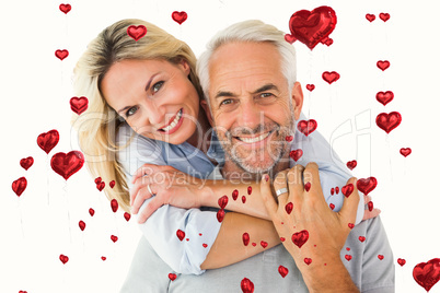 Composite image of happy couple standing and hugging