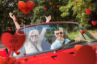 Composite image of mature couple in red cabriolet cheering at ca