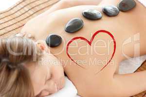 Composite image of bright woman lying on a massage table