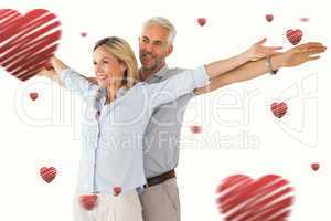 Composite image of happy couple standing with arms outstretched