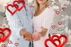 Composite image of happy couple holding their hands out