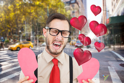 Composite image of geeky hipster crying and holding broken heart