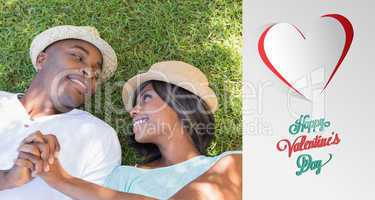 Composite image of happy couple lying in garden together on the