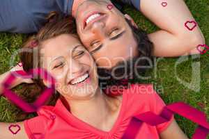 Composite image of two friends smiling while lying head to shoul