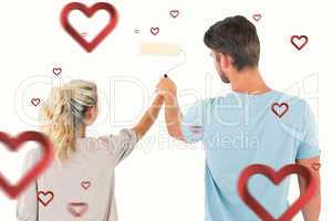 Composite image of young couple painting with roller