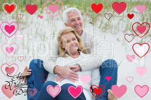 Composite image of romantic senior couple relaxing at beach